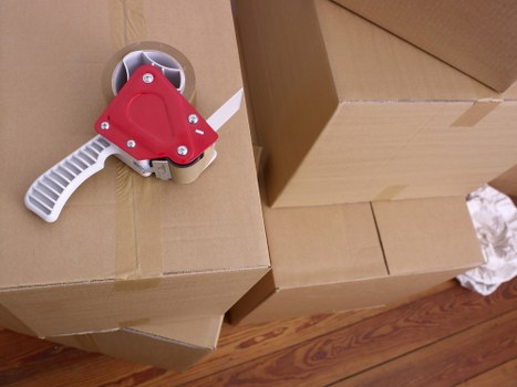Mover carrying a boxed item during a relocation service